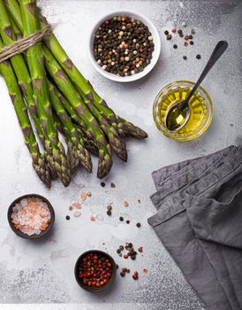 Bunch of fresh green organic asparagus ready for cooking on baking tray with olive oil and seasonings, top view, close up. Asparagus for clean and healthy diet and eating  .