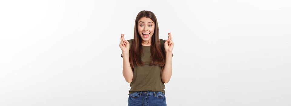 Closeup portrait hopeful beautiful woman crossing her fingers, open eyes, hoping, asking best isolated on gray wall background