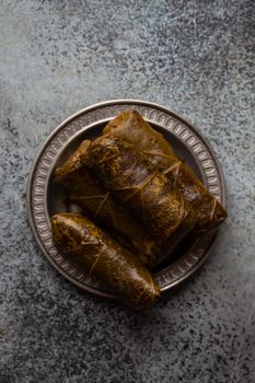 Middle eastern and Mediterranean traditional dish dolma, stuffed vine leaves, from above. Arab snack or appetizer, light and healthy food, top view .