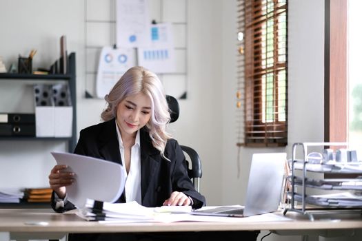 Asian businesswoman working in the office with working documents..