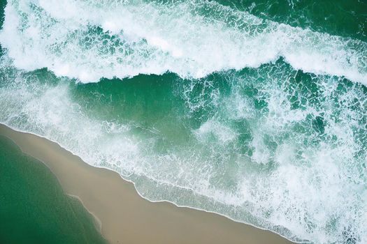 Beach and waves from above. ater background from the top. Summer attacks from the air. Aerial view of a blue ocean