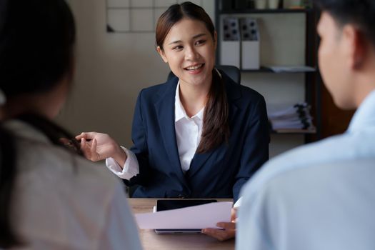 Couples consult with a representative to plan an insurance contract.