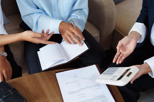 bank employee uses a calculator to calculate loan rates for customers.