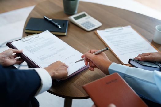 Couples sign important documents with insurance agents.