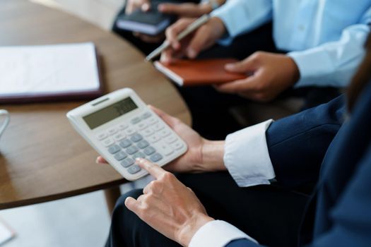 bank employee uses a calculator to calculate loan rates for customers.