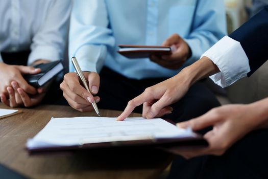 Couples sign important documents with insurance agents.