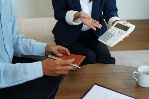 bank employee uses a calculator to calculate loan rates for customers.