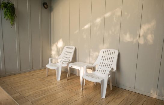 Nobody white chair around outdoor swimming pool in resort hotel empty behind the room for leisure travel vacation