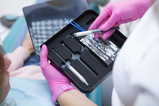 Unrecognizable dentist using teeth whitening kit at dental clinic