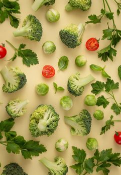 Vegetables food pattern made of broccoli, Brussels sprouts, cucumber, cut tomatoes, herbs, light pastel background. Minimal flat lay design about nutrition, healthy eating, diets, vitamins. Top view