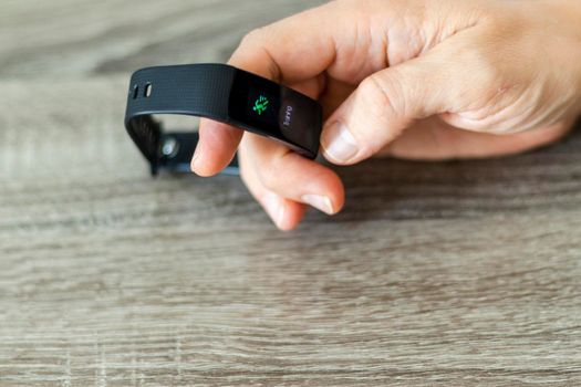 Close up shot of a man setting up a fitness wristband.