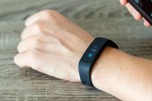 Close up shot of a man setting up a fitness wristband.