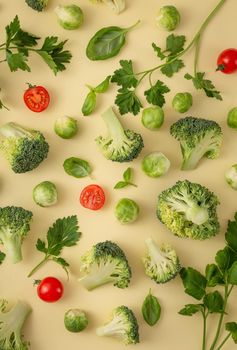Vegetables food pattern made of broccoli, Brussels sprouts, cucumber, cut tomatoes, herbs, light pastel background. Minimal flat lay design about nutrition, healthy eating, diets, vitamins. Top view