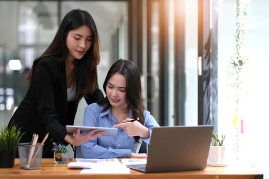 Two asian business woman work together to get the job done at the office..