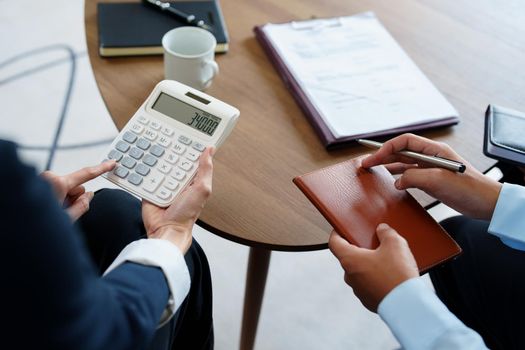 bank employee uses a calculator to calculate loan rates for customers.