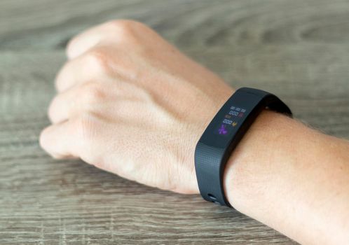 Close up shot of a man setting up a fitness wristband.