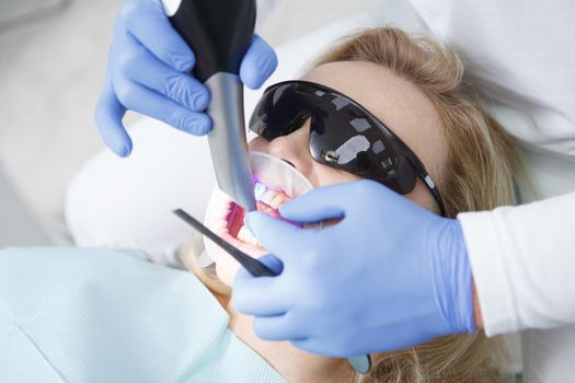 Close up of unrecognizable dentist doing dental scanning of patients teeth