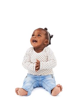 Encore. Studio shot of a happy baby girl sitting against a white background