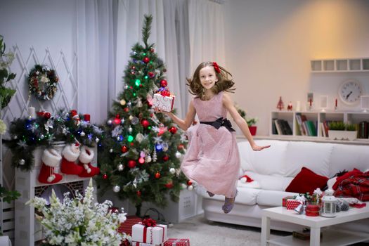 A girl with a Christmas present. Jump with happiness. Get a dream