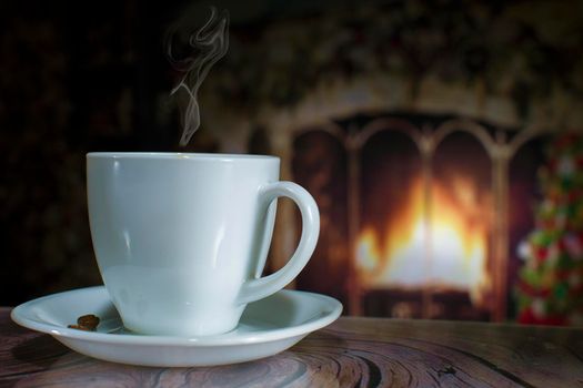 Cup of coffee with smoke on the background of the Christmas fireplace and Christmas tree