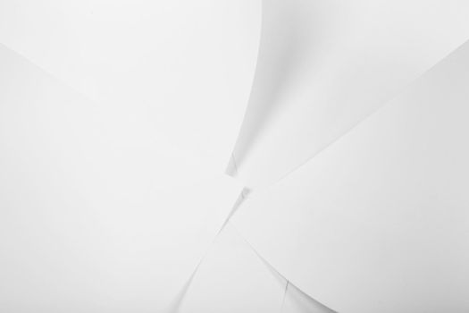 White sheets of office paper are twisted and scattered. Paper white abstract background.