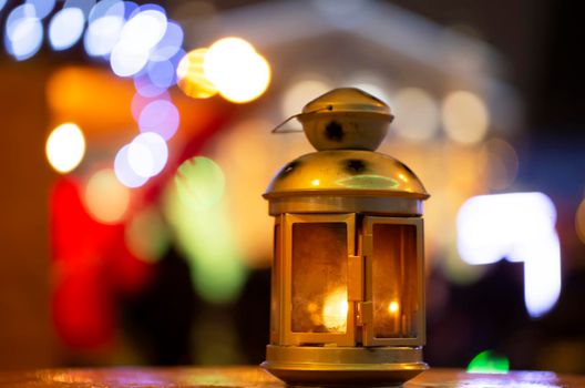 Golden vintage lantern on evening bokeh background.Yellow lantern on a bench at night. The background is blurred. Old lantern. Evening light. Bokeh