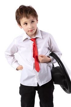 Funny little boy is holding a car steering wheel. Young driver on a white background.