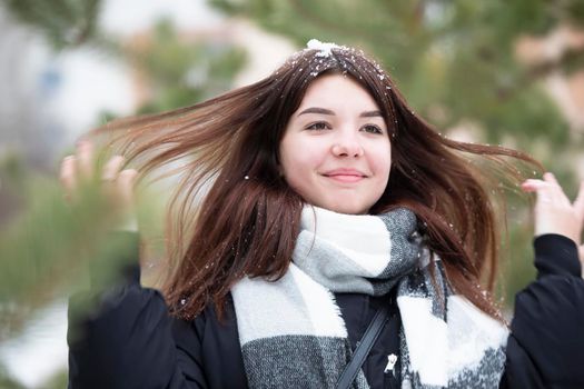 Happy teen girl with long snowy hair in winter.