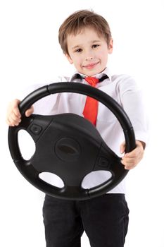 Funny little boy is holding a car steering wheel. Young driver on a white background.