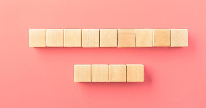 Wooden cubes isolated on pastel pink background with a place to insert text