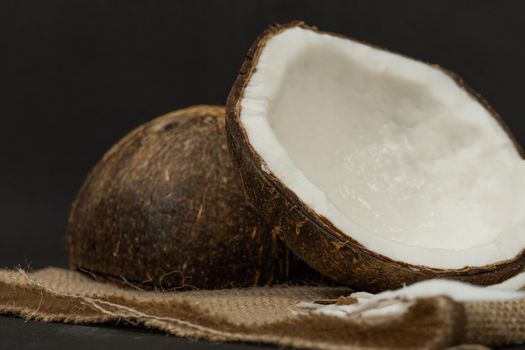 fresh coconut on black background drawing its water, raffia cloth