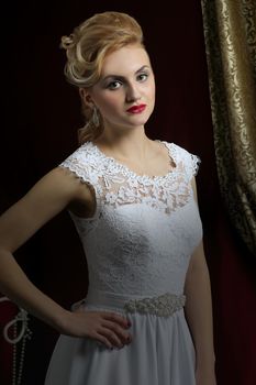 Beautiful bride with a wedding hairstyle - on a dark background. Portrait of a gorgeous bride. Wedding.