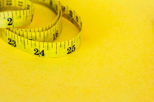 Yellow measuring tape with customizable space for text or ideas. Copy space and weight loss concept.