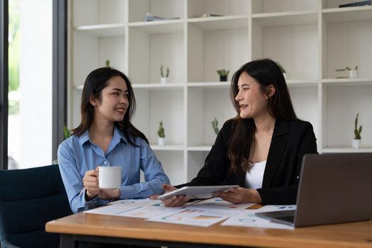 Two asian business woman workers smiling happy and confident. Working together with smile on face at the office.