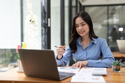 Business woman using calculator for do math finance on wooden desk in office and business working background, tax, accounting, statistics and analytic research concept.