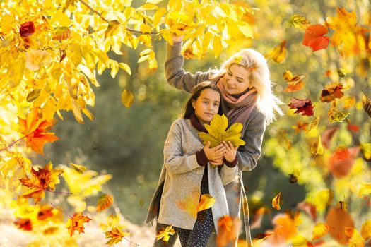 Happy family on autumn walk Mother and daughter walking in the Park and enjoying the beautiful autumn nature. High quality photo