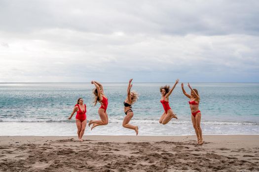 Big happy family or group of five friends is having fun against sunset beach. Beach holidays concept
