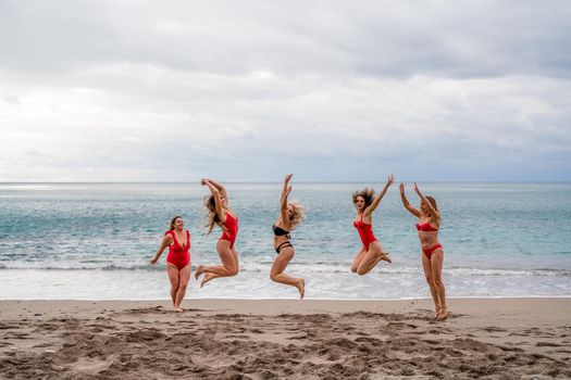 Big happy family or group of five friends is having fun against sunset beach. Beach holidays concept