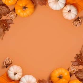 Autumn frame flat lay from pumpkins and fallen leaves and sweater with space for text. High quality photo