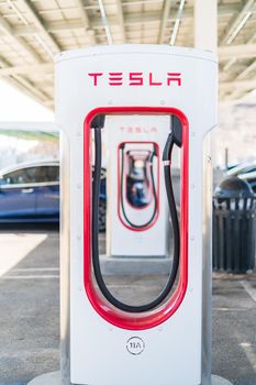 Baker, California, USA-October 12, 2021 - Tesla supercharging station during the day.