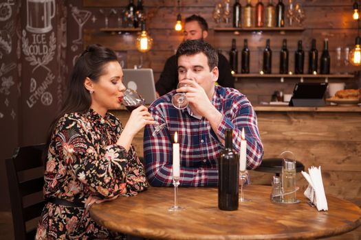 Happy couple drinking wine when having date in restaurant. Beautiful couple.