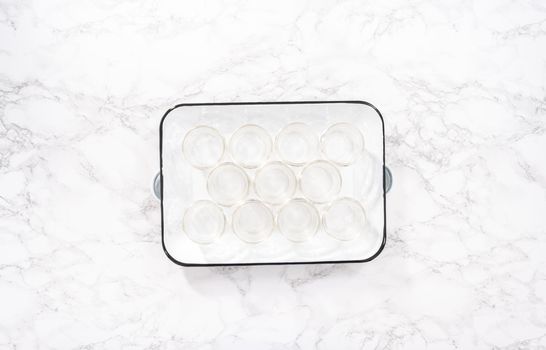 Flat lay. Empty small mason jars on a white metal tray.