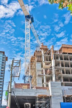 Concrete high rise residential building under constraction on blue sky background