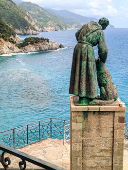 statue of St. Francis with panorama of the city of Monterosso in Liguria, travel reportage