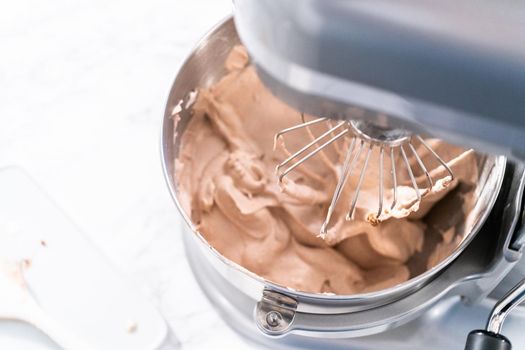 Mixing ingredients in a standing kitchen mixer to make homemade chocolate ice cream.