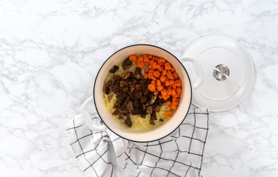 Flat lay. Cooking creamy wild mushroom soup made in an enameled dutch oven.