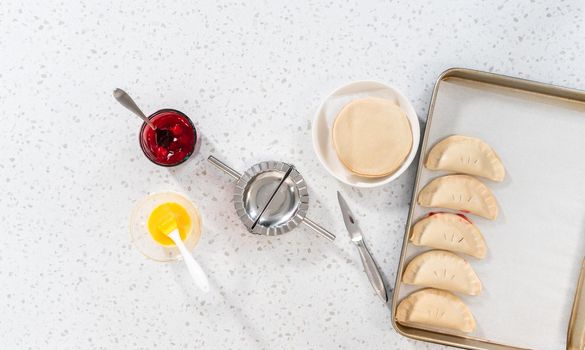 Flat lay. Filling empanada dough with cherry pie filling to make sweet cherry empanadas in the air fryer.