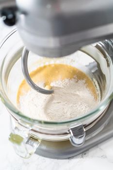 Mixing ingredients in kitchen mixer to bake mini Easter bread kulich.