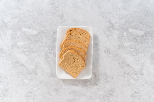 Flat lay. Stale bread on a white plate to make bread crumbs.