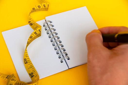 Blank notepad and measuring tape with customizable space for text or ideas. Copy space and weight loss concept